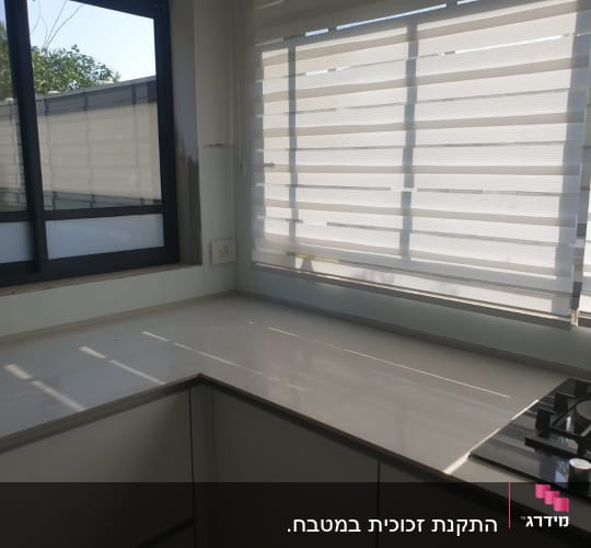 חלון זכוכית גדול עם תריסים לבנים במטבח